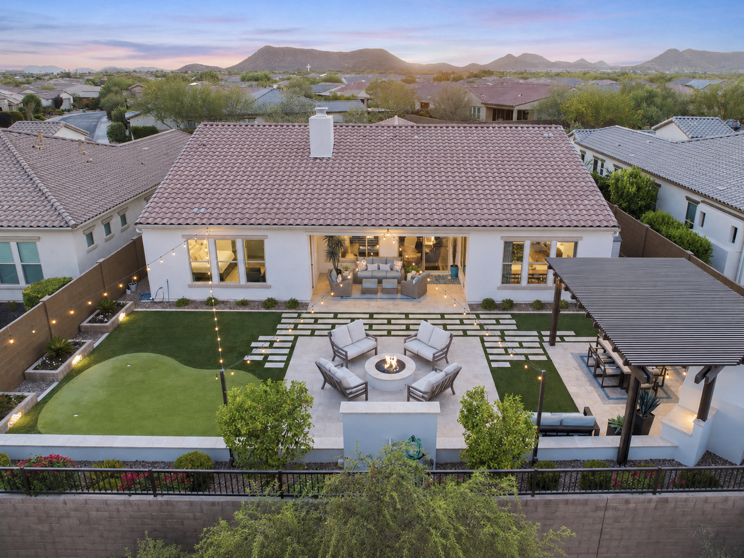 Sonoran Hills, Scottsdale: aerial dusk photo of a single-story home with a tile roof and backyard putting green