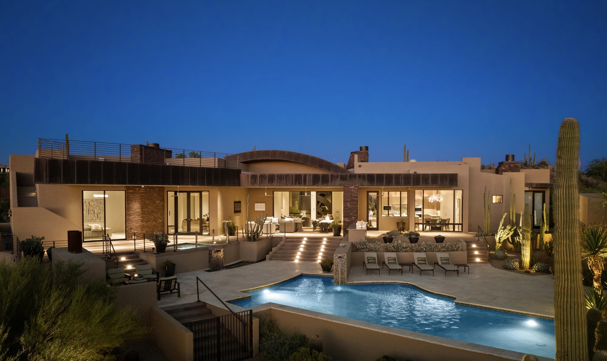 DC Ranch, Scottsdale: twilight exterior of a single-story desert modern estate with an illuminated pool